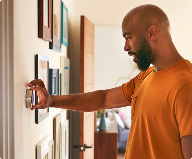 Man adjusting thermostat