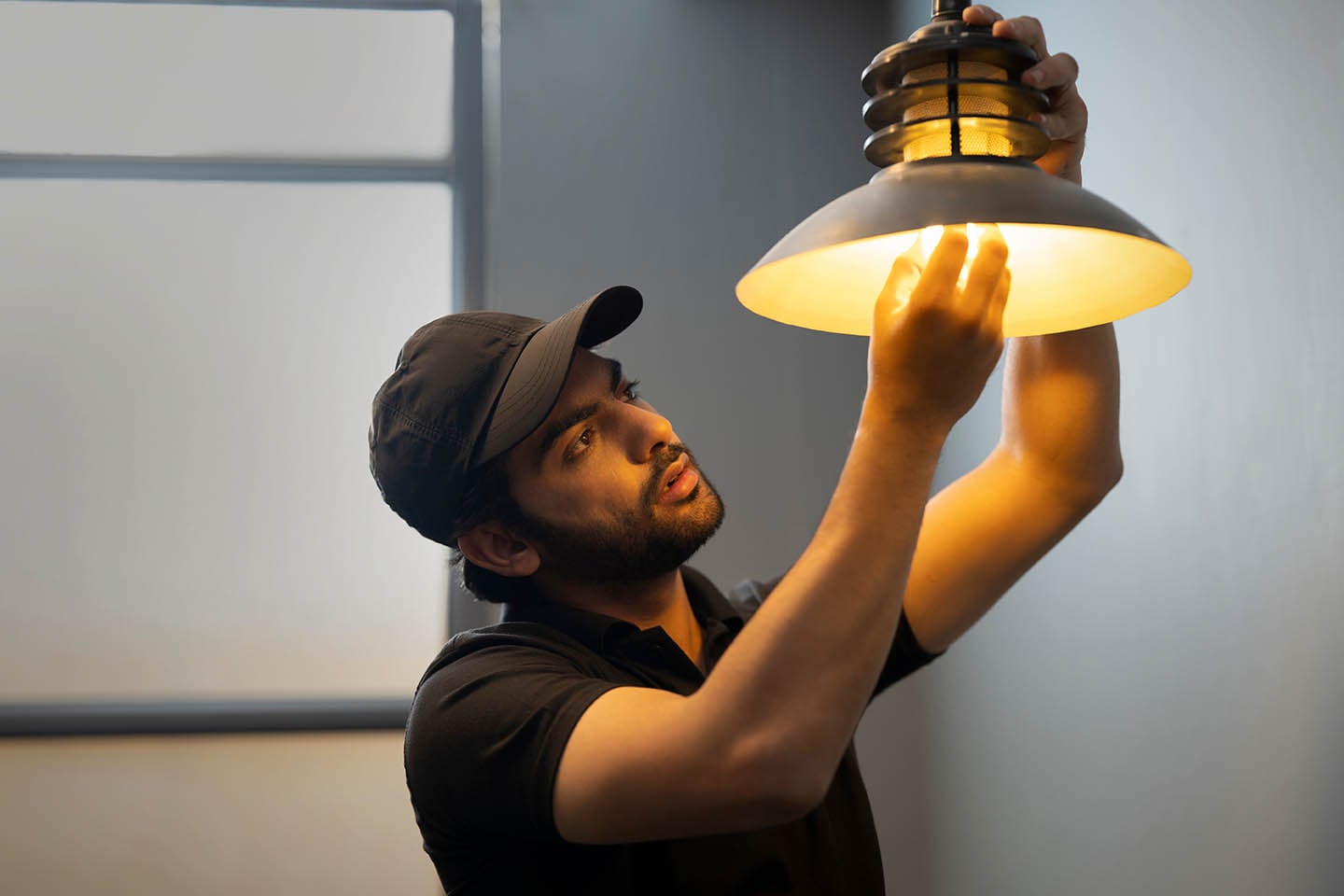 Technician installing a light fixture.