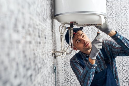 man fixing under water heater