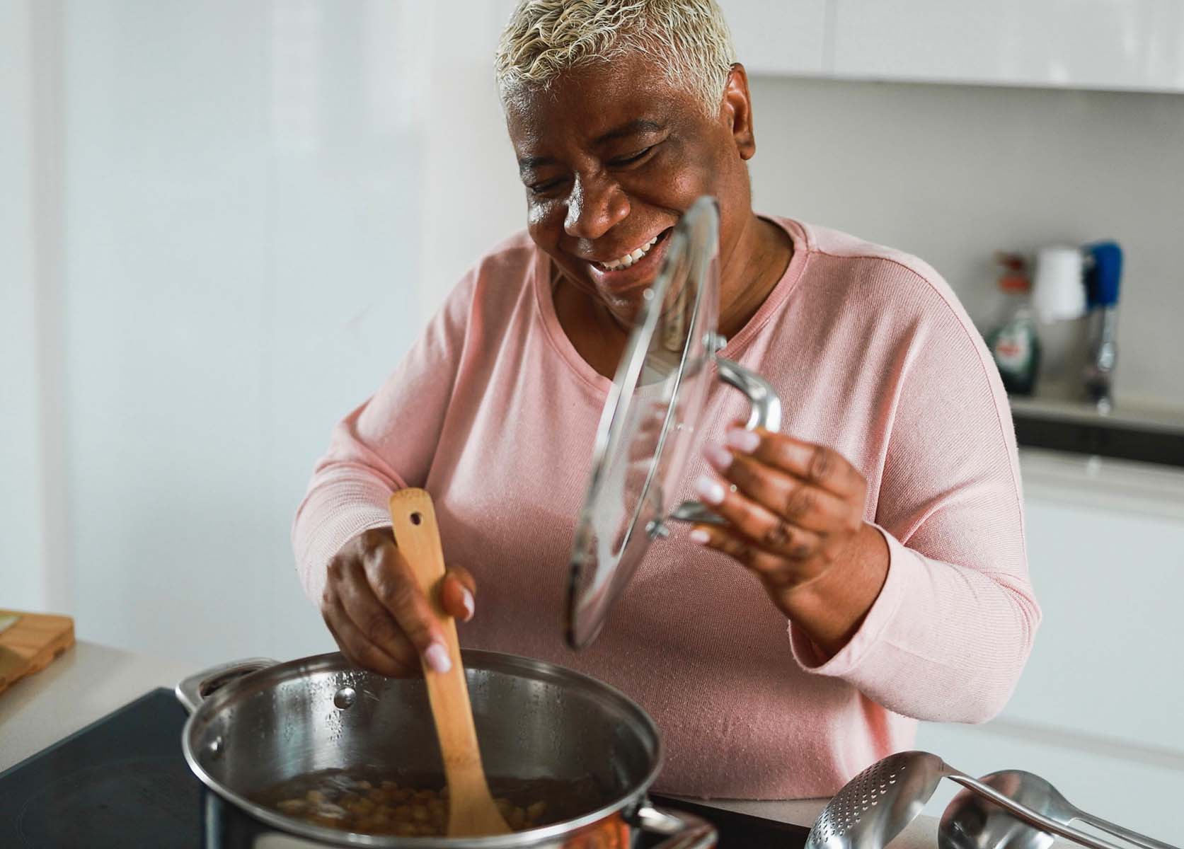 elderly woman stirring a pot in the kitchen