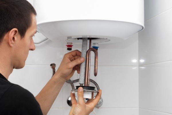 Person installing a water heater tank