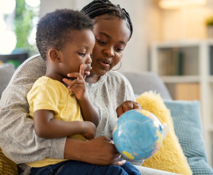 mother and child looking at a globe