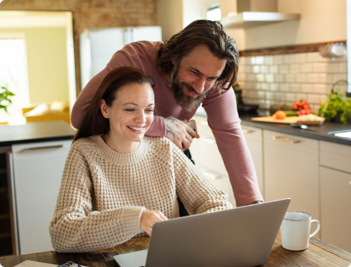 Smiling couple looking at laptop screen