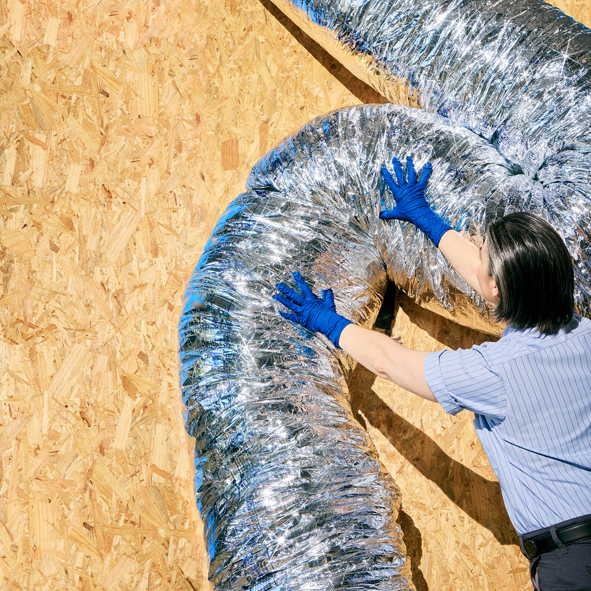 Technician fixing ductwork.