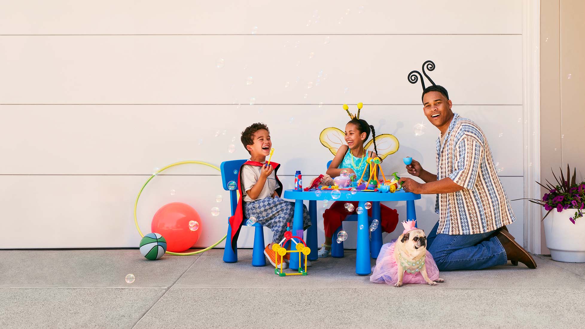 smiling father sitting with his kids and blowing bubbles