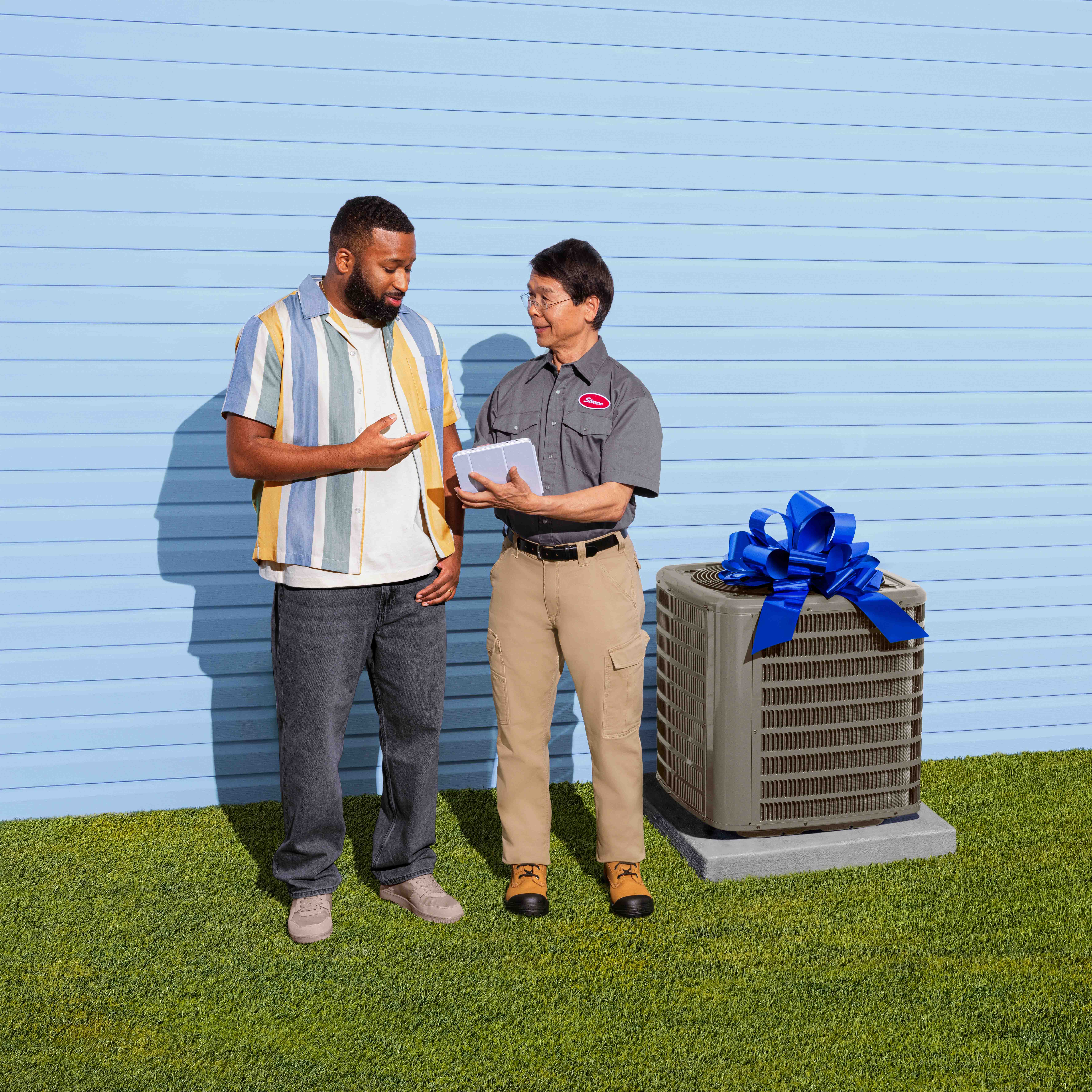 Man standing next to technician with AC unit
