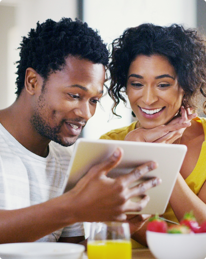 A couple looking at a tablet together.