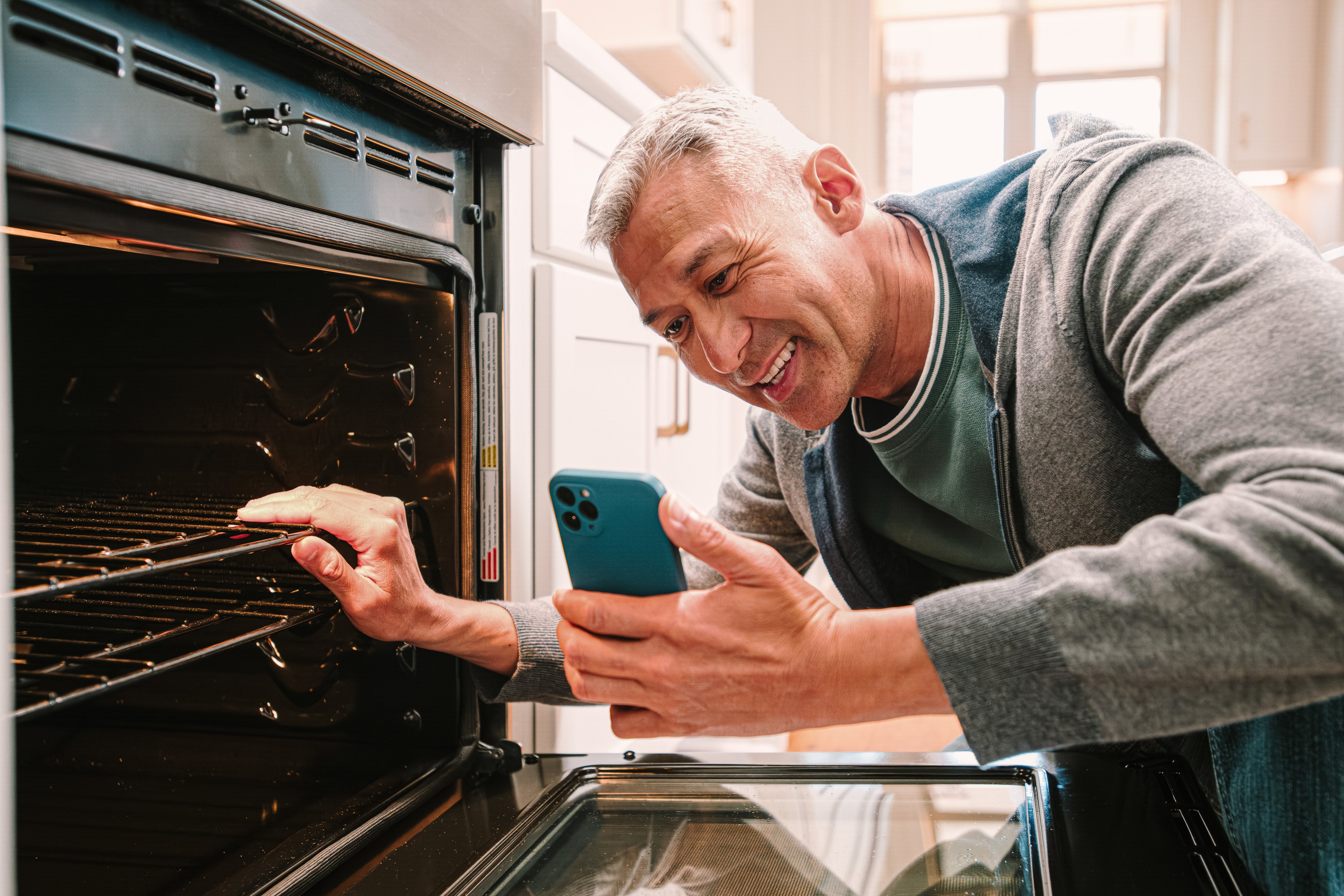 Homeowner on video chat while inspecting his oven