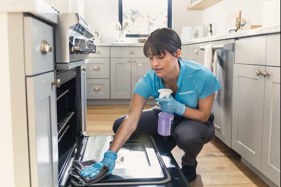 woman cleaning inside of oven