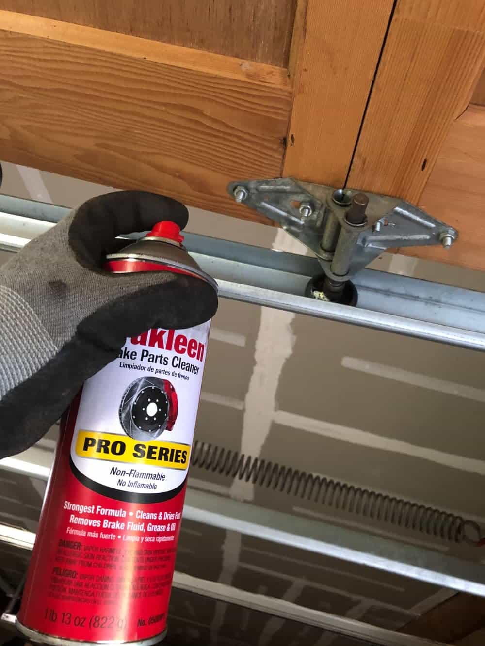 spraying parts cleaner on door tracks