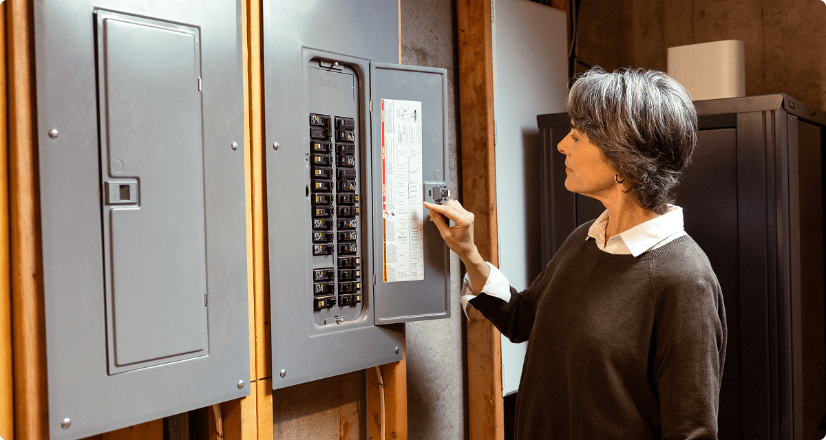 Homeowner checking inside electrical breaker box