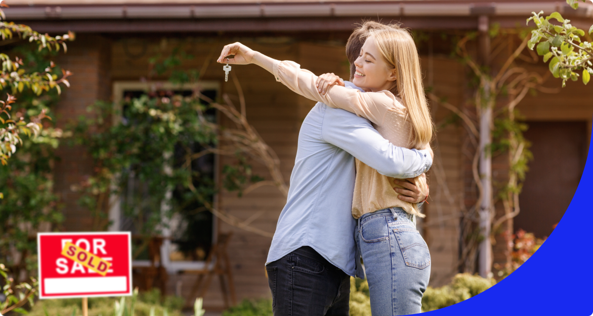 Couple hugging in front of house